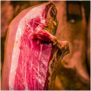 Een ham in kraam in een markthal. De verlichting is vreemd waardoor de foto niet mooi is, © Arno Lucas